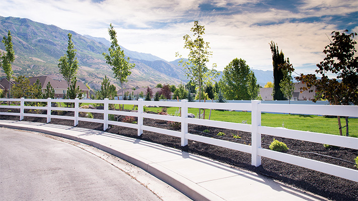 White three-rail ranch rail vinyl fence adjacent to a road, some of our white vinyl fence panels near Chatsworth, CA.