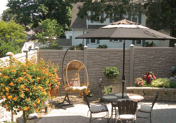 Tan stone Traver simulated fencing surrounding a patio area.